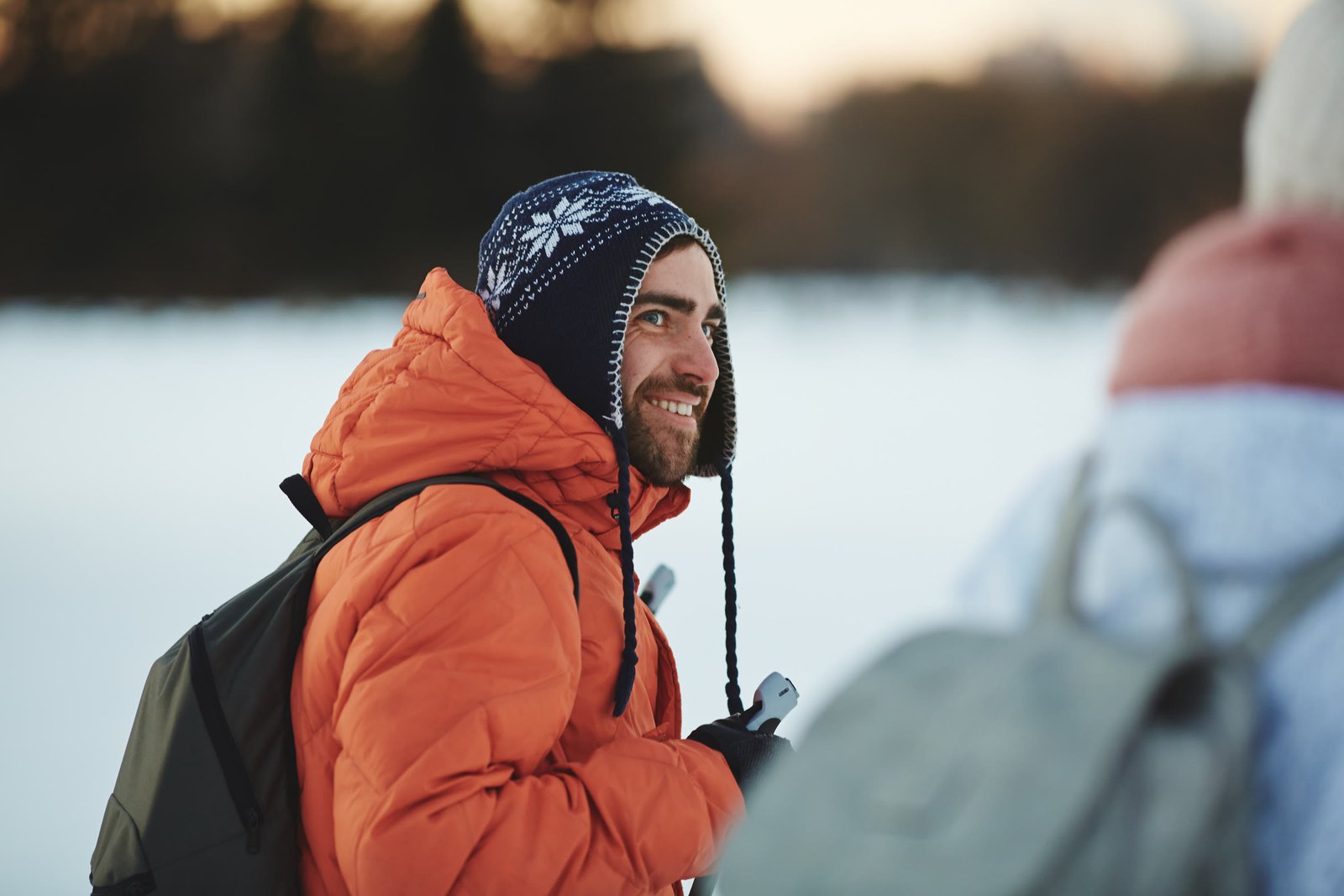 Caminhante com bastões em paisagem de inverno