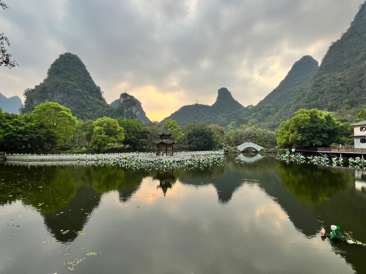 Pagode refletido num lago calmo entre montanhas, no fim da tarde