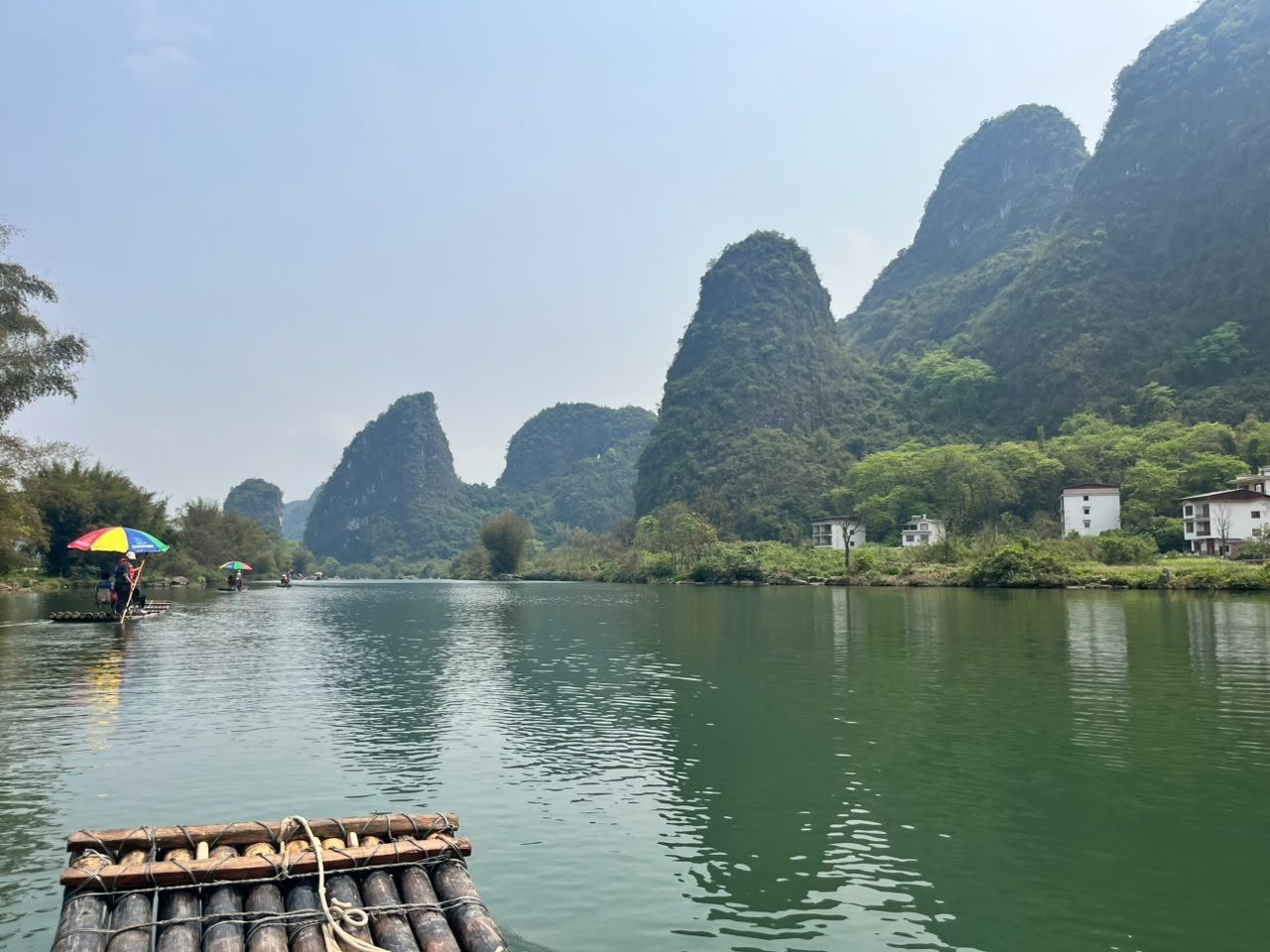 Balsa de bambu descendo o rio entre montanhas cársticas